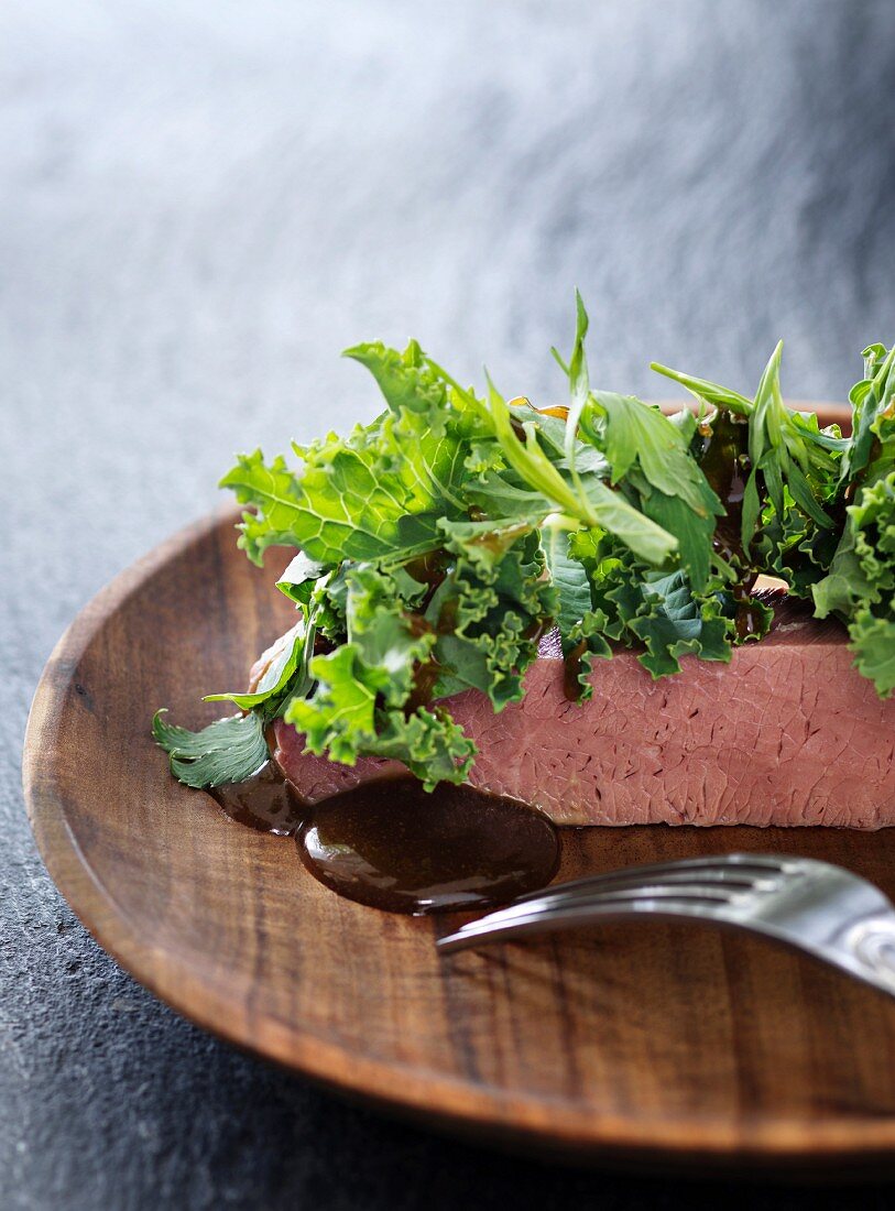 Veal brisket with sauce and raw green kale