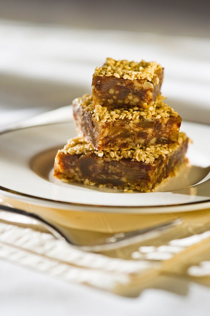 A stack of date and ginger slices with sesame seeds