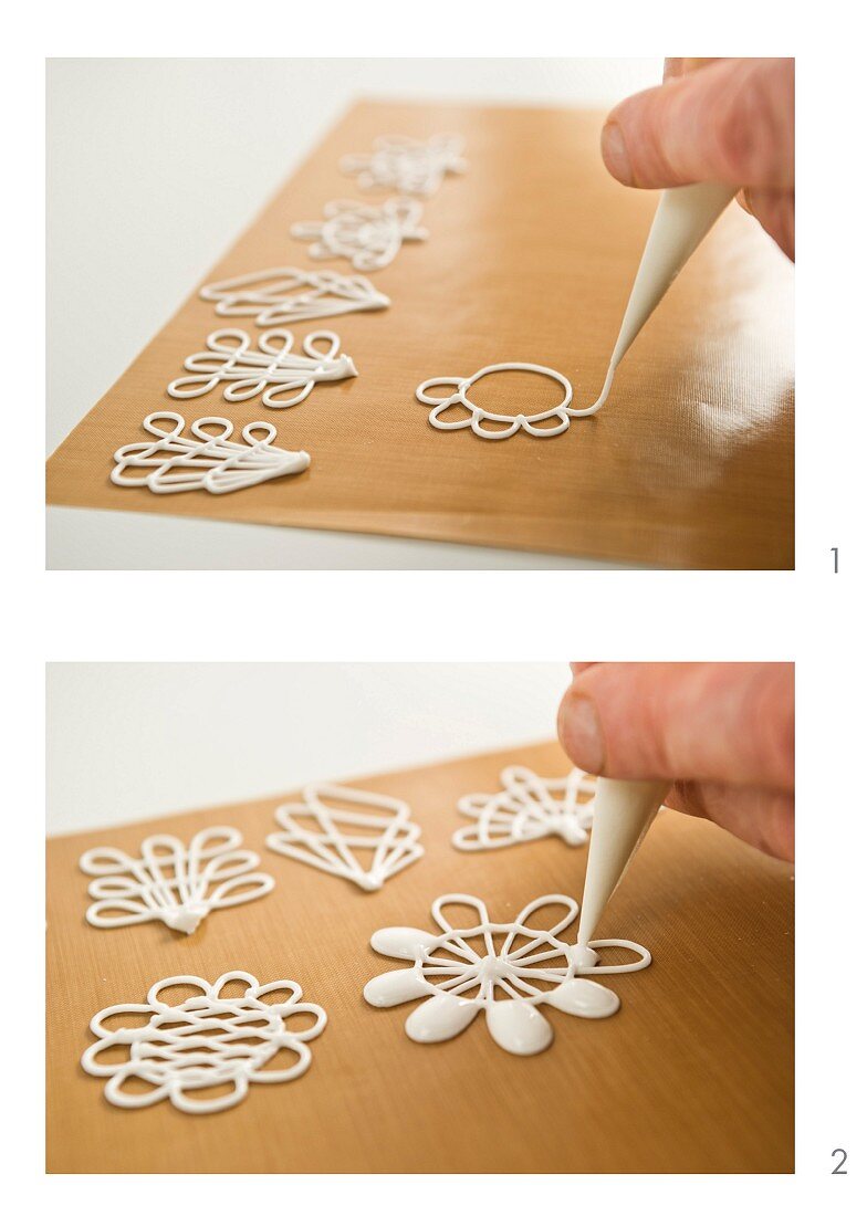 White chocolate flowers being pipped onto baking paper