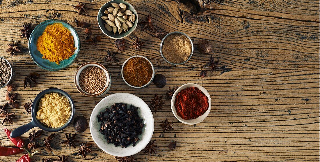 Assorted spices on a wooden surface