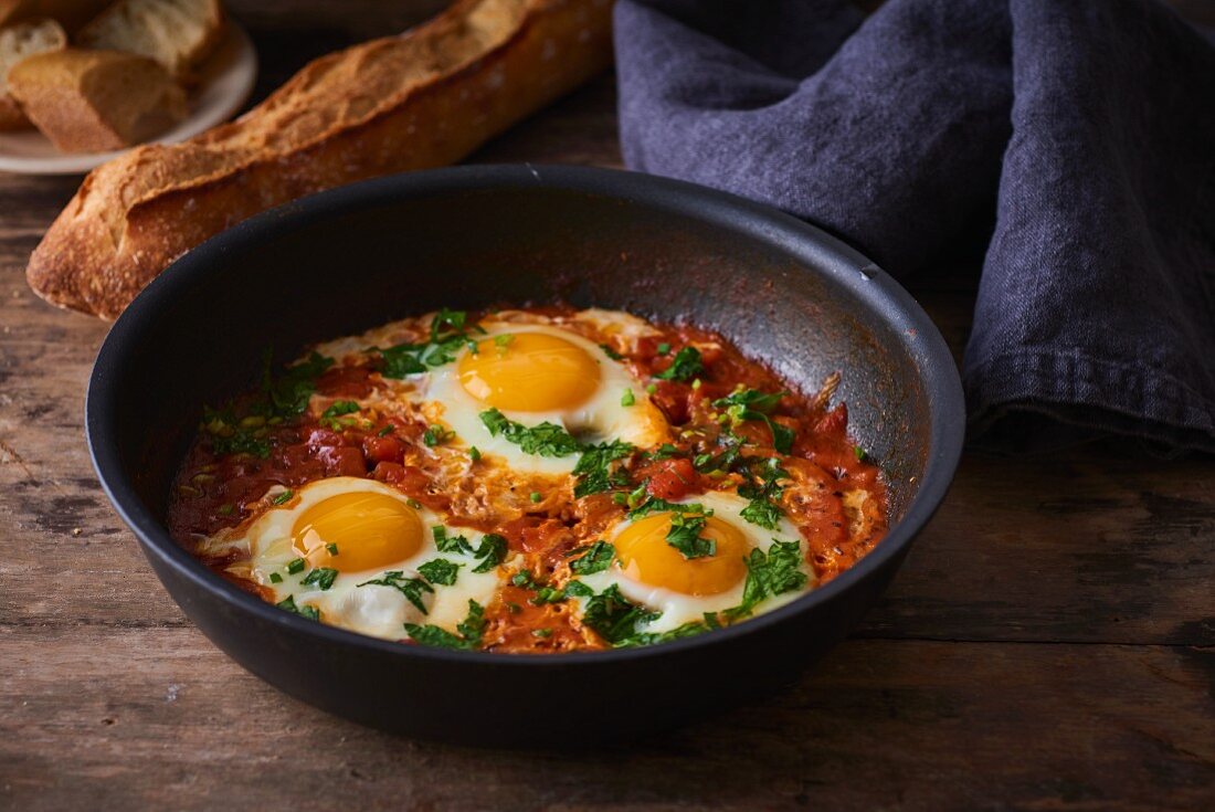 Fried eggs with tomatoes, peppers and onions