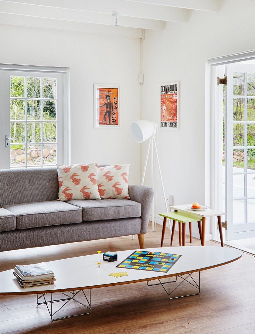 Klassiker Coffeetable vor grauer Couch mit weisser Stehleuchte in Wohnzimmerecke