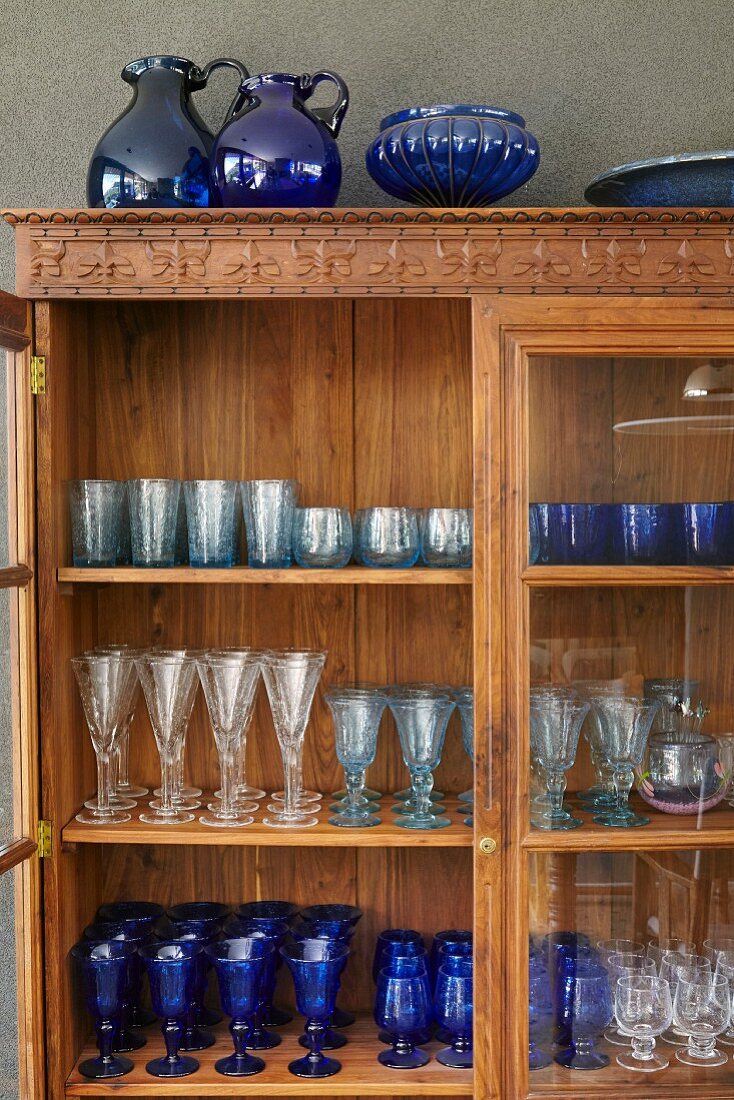 Collection of glasses in old wooden display case