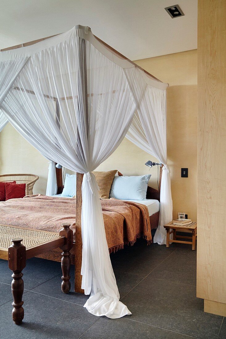 Canopied bed in bedroom in shades of brown