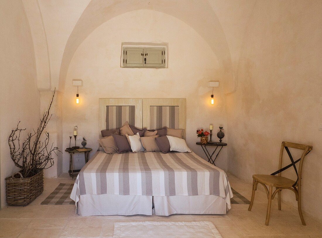 Doppelbett mit gestreifter Tagesdecke in apulischem Trullo