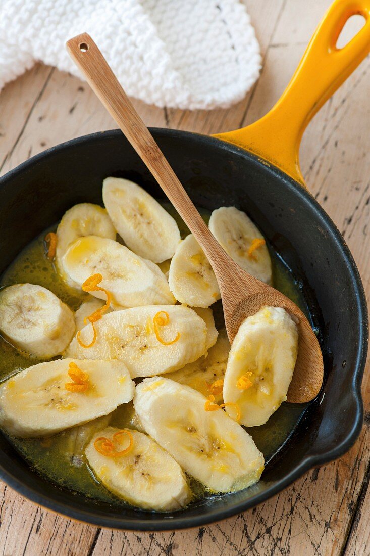 Warm bananas slices with orange syrup
