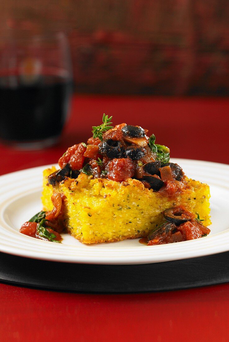 Polenta cake with olive and tomato and spinach