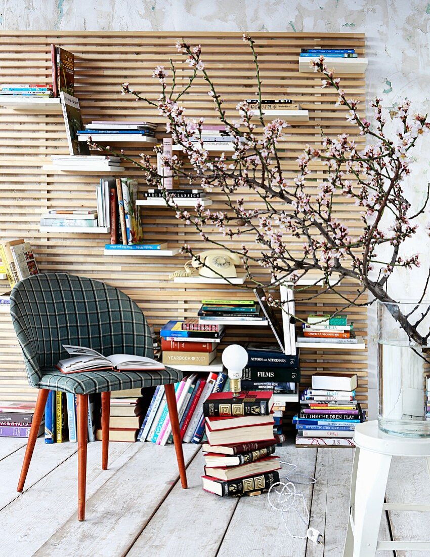 DIY table lamp with base made from books next to fifties-style chair