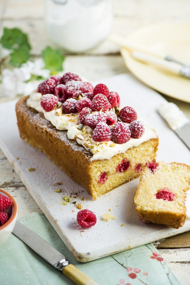 Raspberry cake with icing sugar and pistachios, sliced