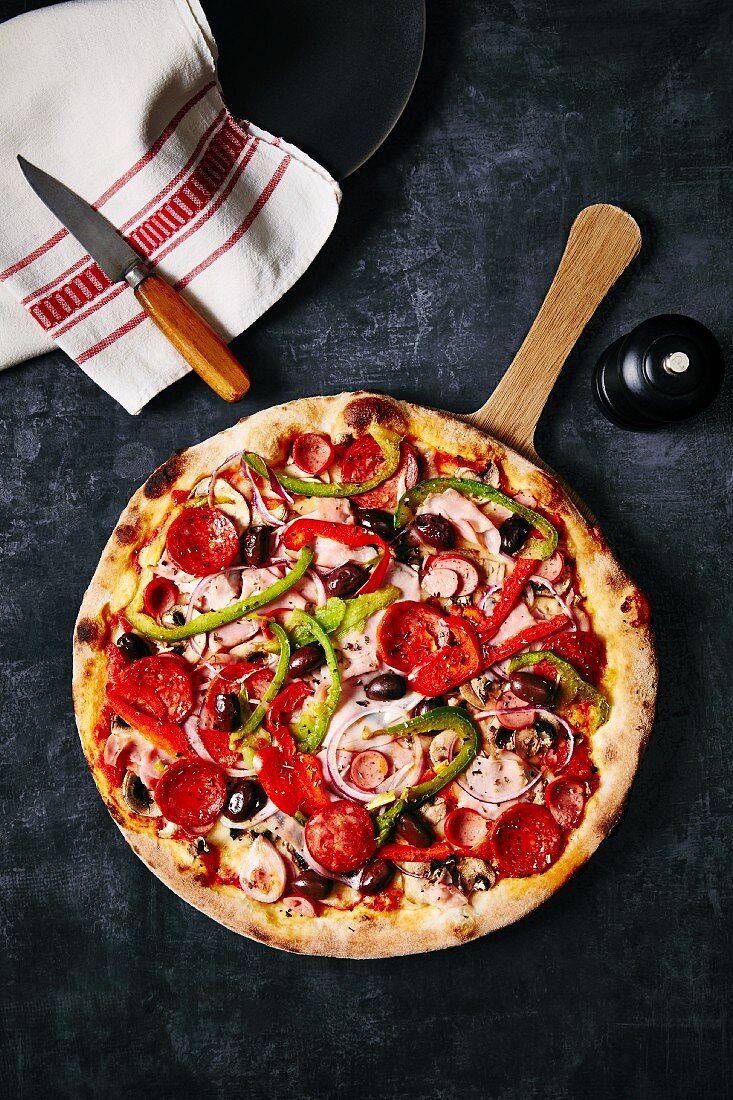 Pizza mit Salami, Schinken, Paprika, Oliven & Zwiebeln (Aufsicht)