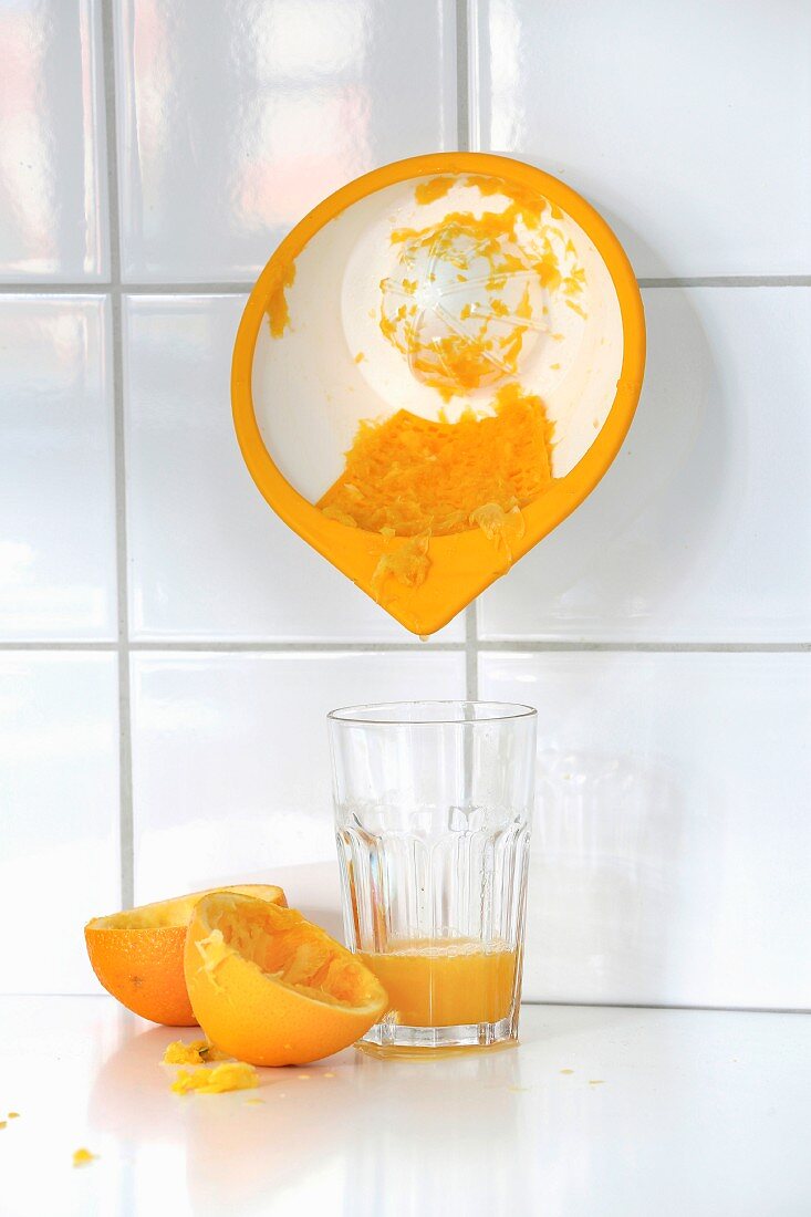 Zitruspresse für die Wand und frisch gepresster Orangensaft im Glas