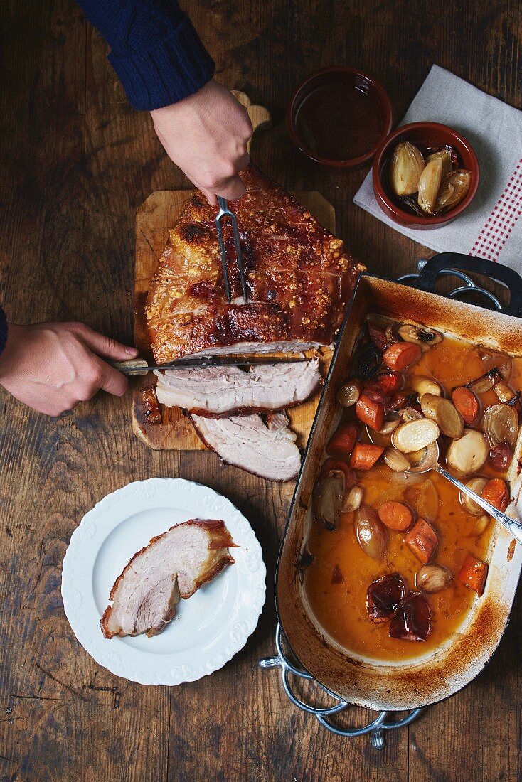 Crispy roast pork and root vegetables in a roasting tin