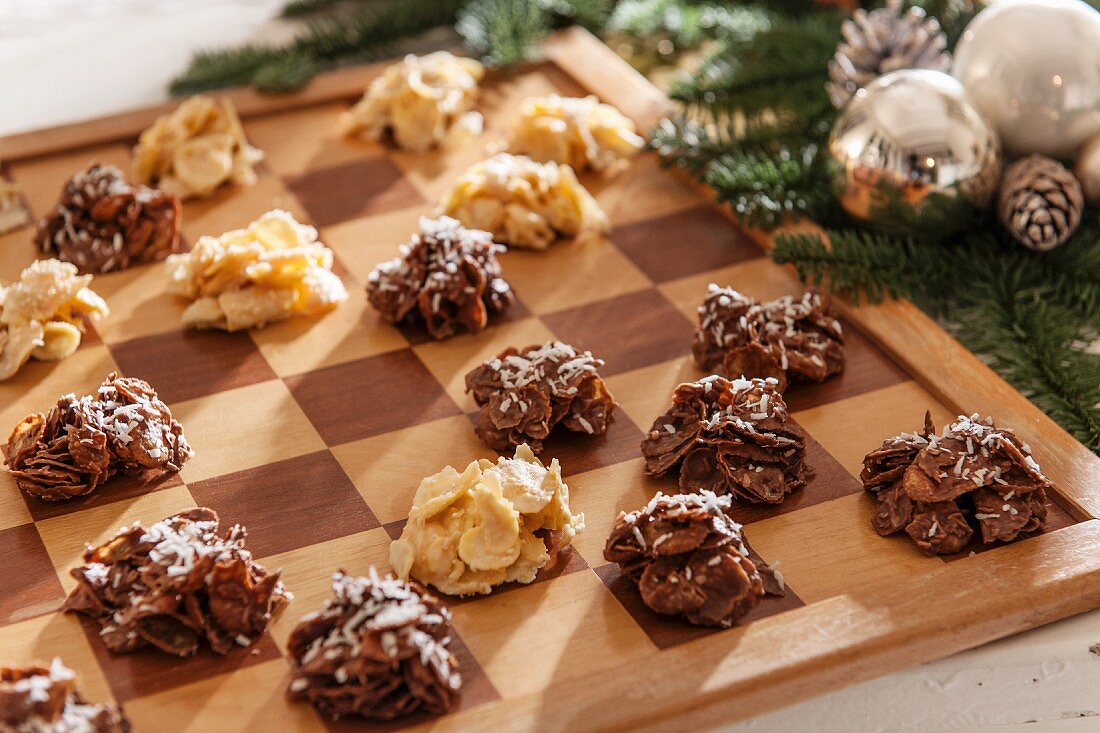 Helle und dunkle Schokocrispies auf Schachbrett und Weihnachtsdeko