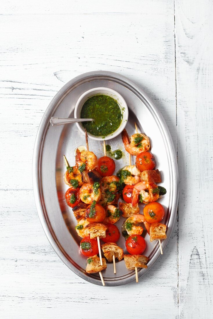 Prawn skewers with cherry tomatoes, bread and a basil sauce