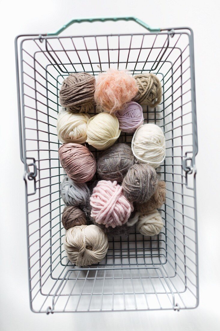 Balls of pastel wool in shopping basket
