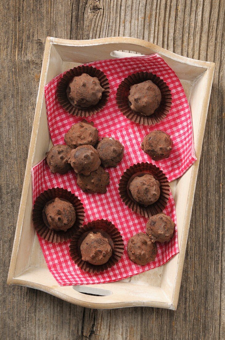 Truffle pralines on a wooden tray (seen from above)