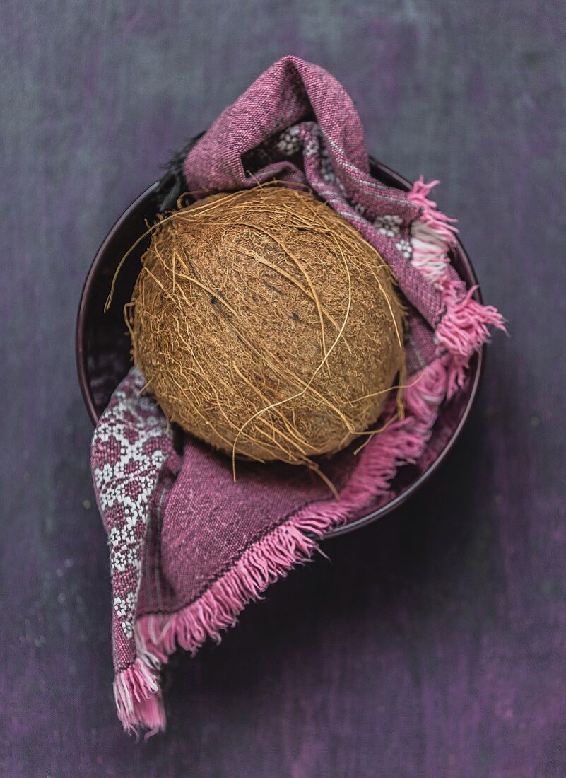 A coconut on a cloth in a bowl