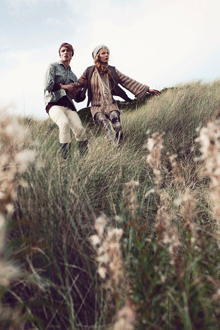 Junges Paar steht an Hügel mit Gras