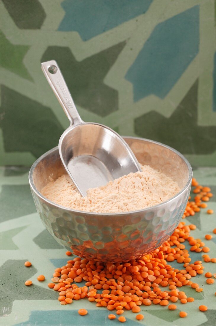 A bowl of red lentil flour with a scoop