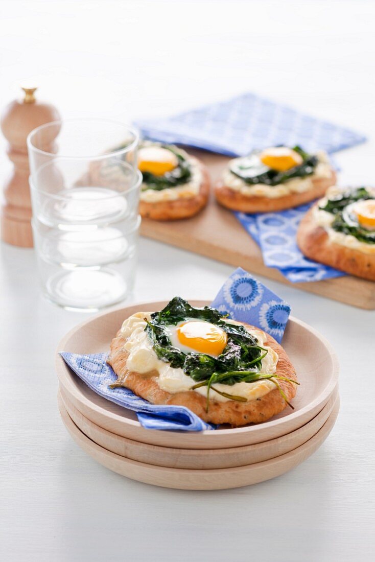 Naan pizzas with spinach, goat's cheese and fried eggs