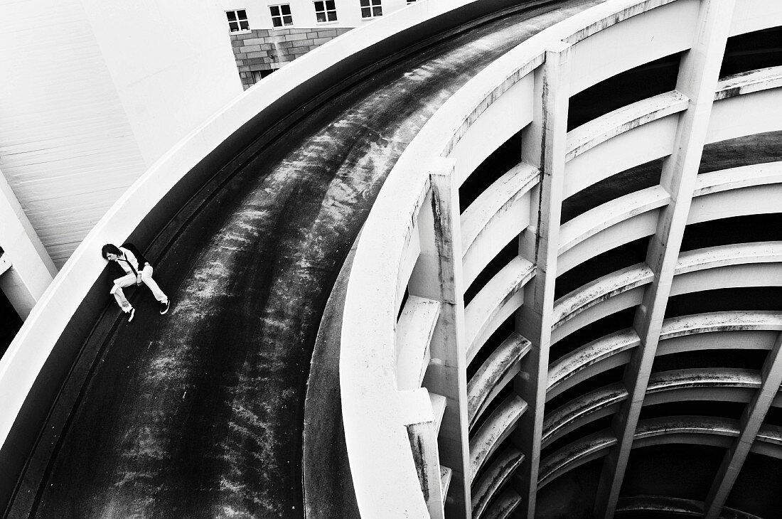 A young man at the top of a round car park (black-and-white shot)