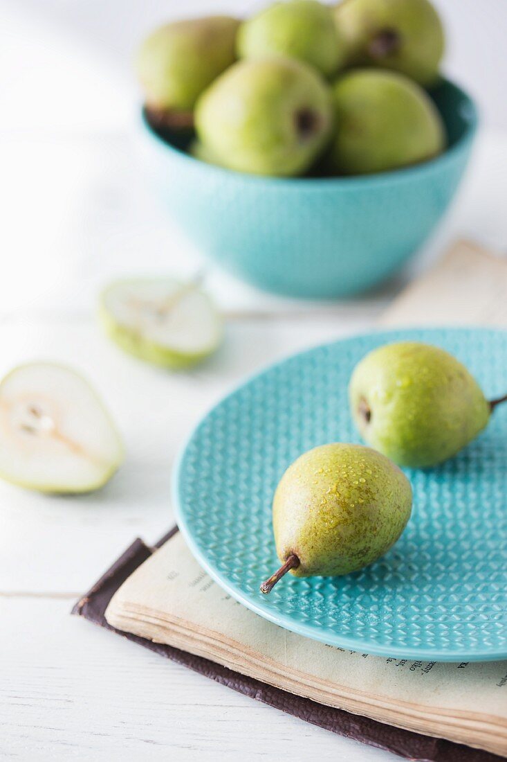 Fresh ripe pears on a plate and in a bowl