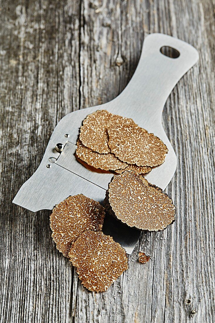 Summer or burgundy truffles (Tuber blotii) sliced on a truffle slicer