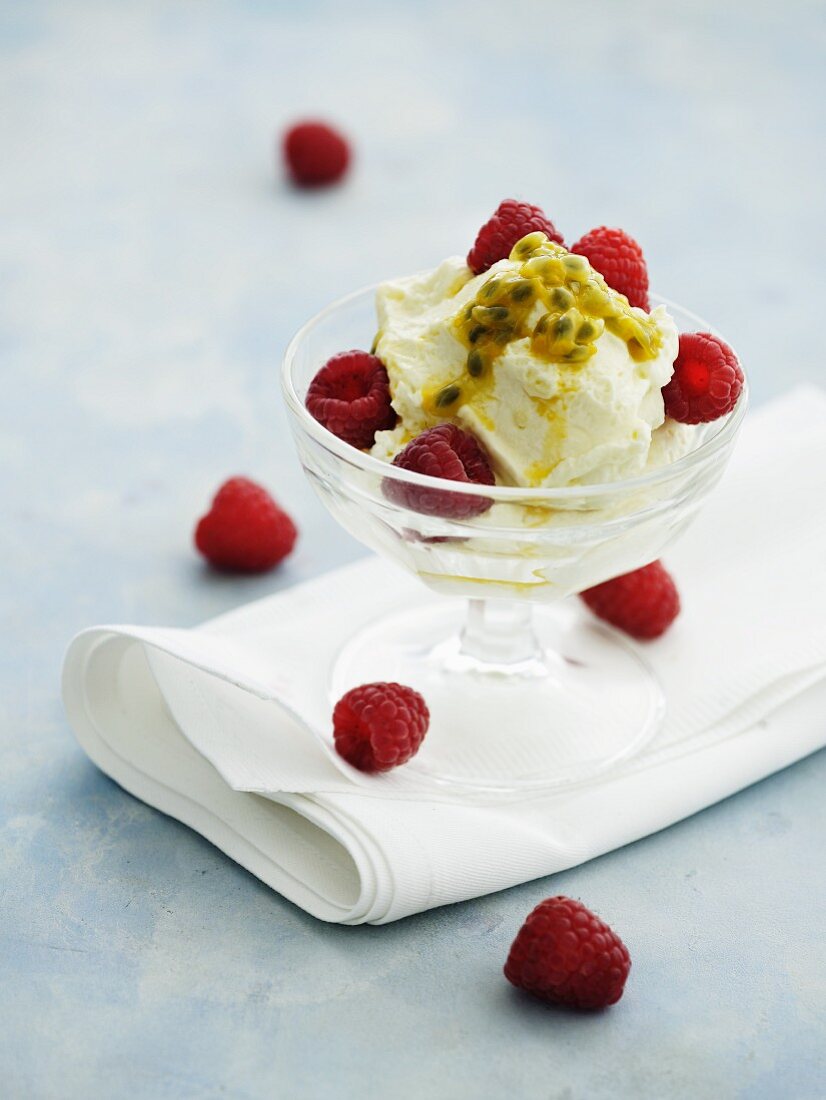 White chocolate mousse with passion fruit sauce and fresh raspberries