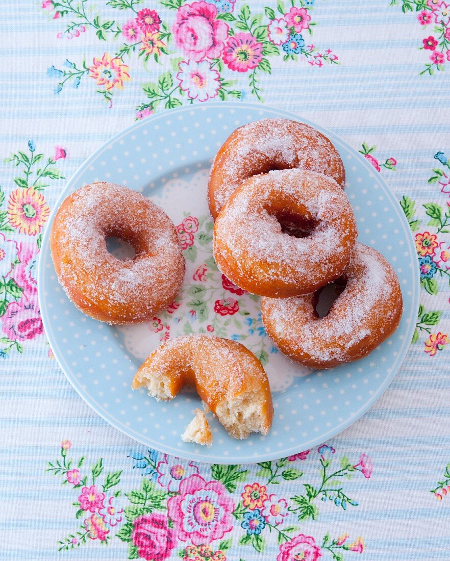 Gezuckerte Doughnuts auf geblümten Teller