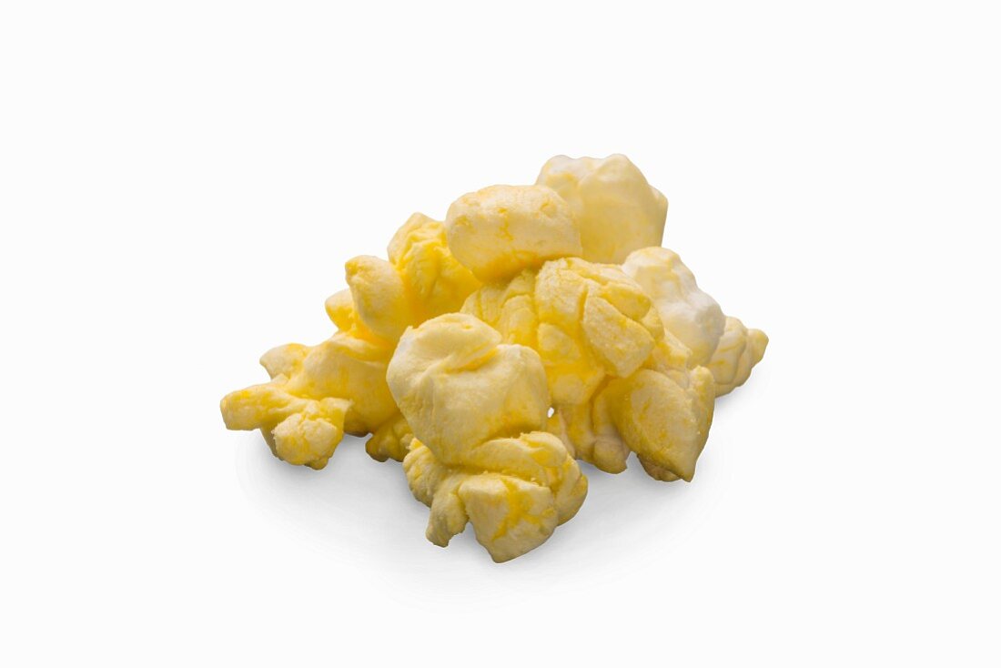 Butter-Popcorn vor weißem Hintergrund (Nahaufnahme)