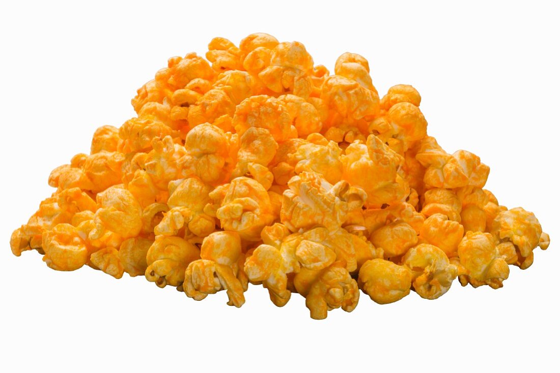 A pile of cheddar popcorn on a white surface