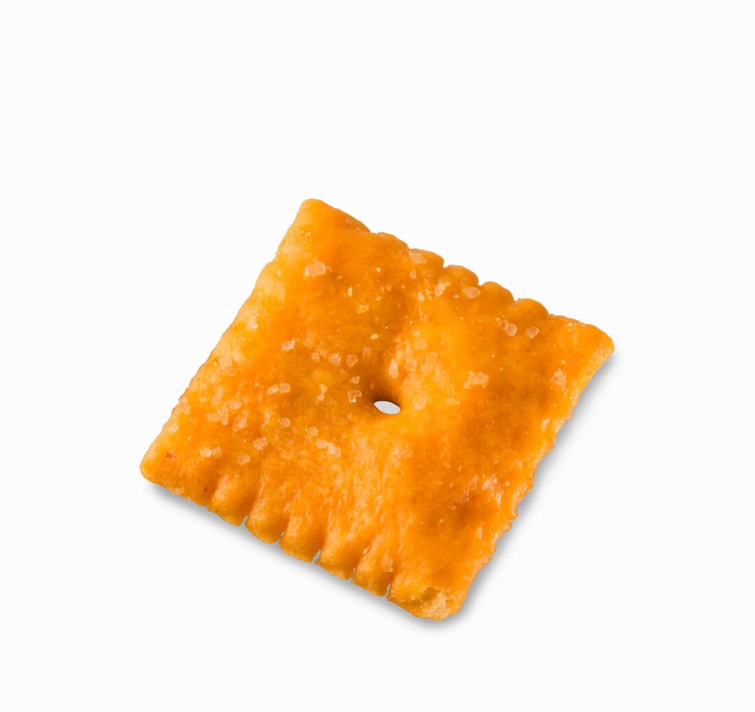 Ein Cheddar-Cracker vor weißem Hintergrund (Nahaufnahme)