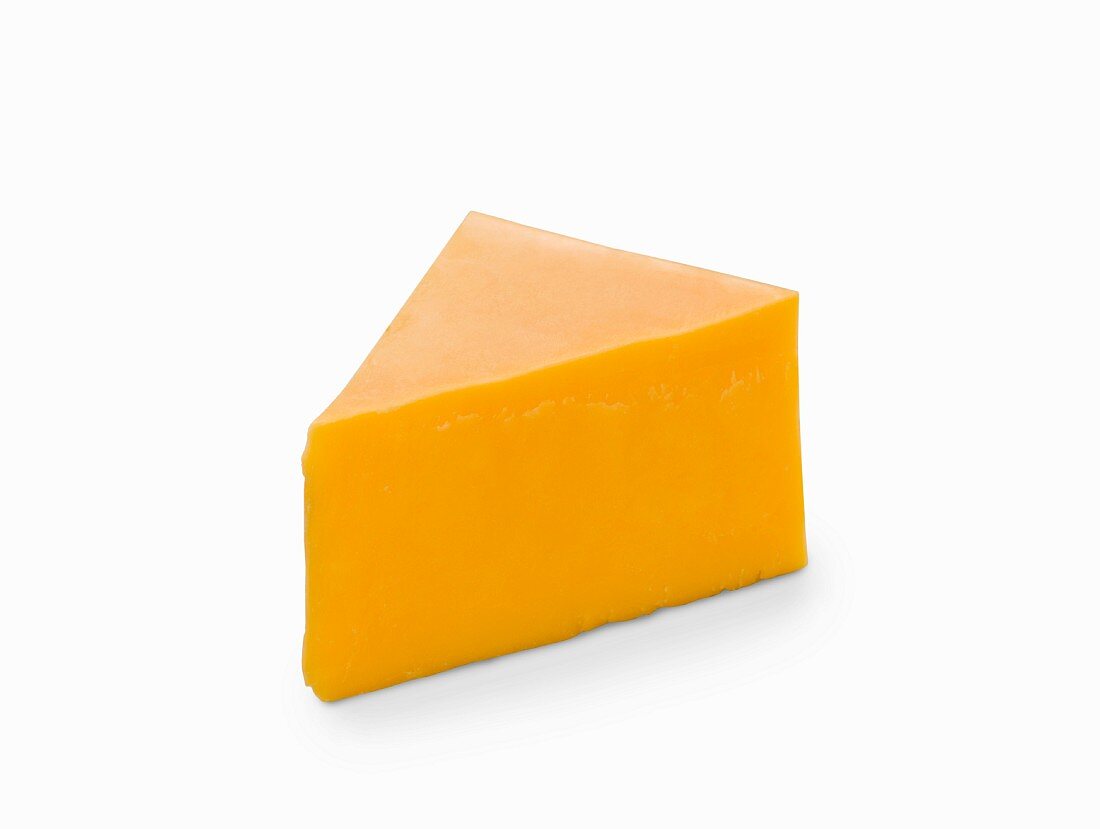 A slice of cheddar cheese on a white surface