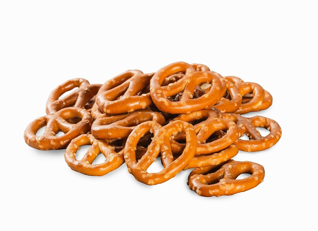A pile of mini salted pretzels on a white surface