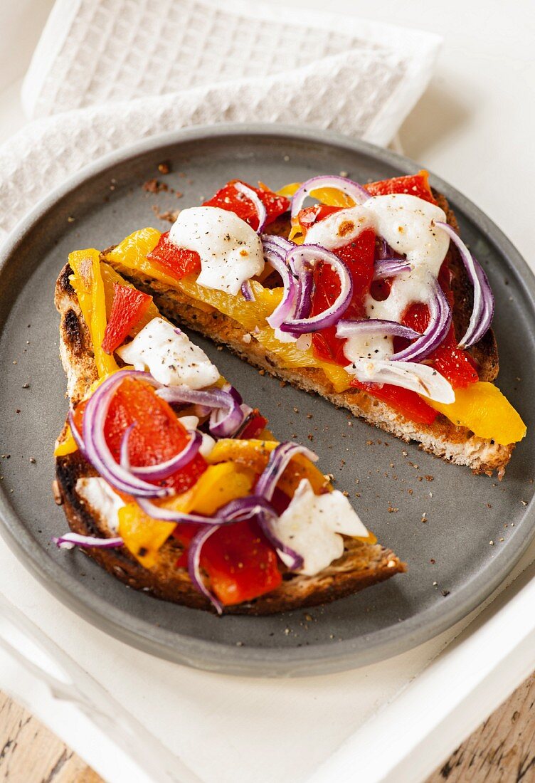 Grilled bread topped with peppers, onions and mozzarella