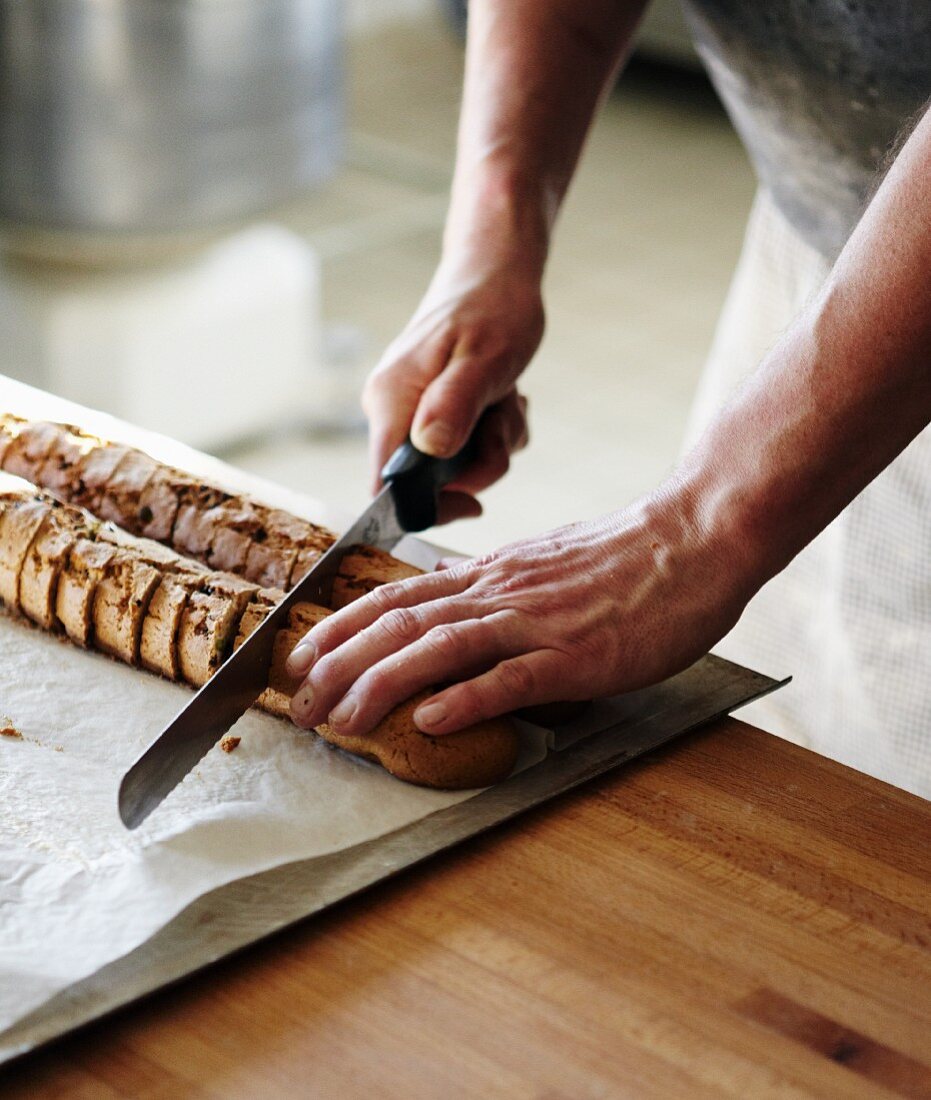 A baker slicing crusty bread