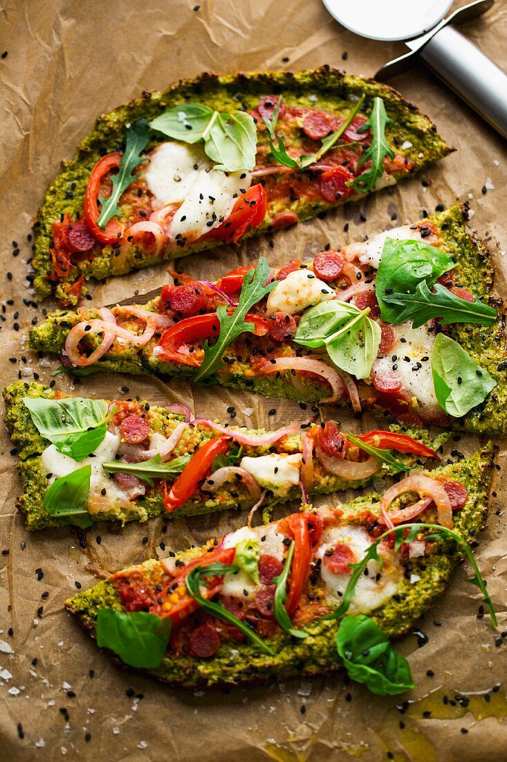 Brokkoli-Pizzaboden mit Tomaten, Salami, Rucola, Basilikum, Zwiebel und Mozzarella