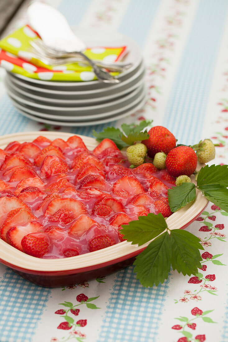 Erdbeerkuchen mit Tortenguss auf Tisch im Freien