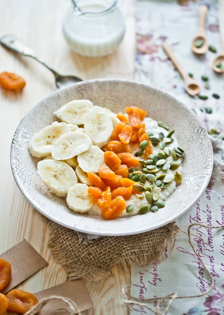 Millet flakes of almond milk, bananas, dried apricots and pumpkin seeds