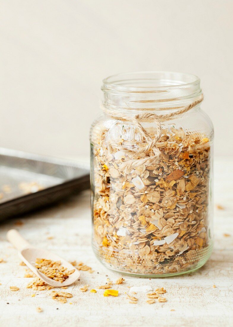 Homemade granola muesli with mango and coconut in a screw-top jar