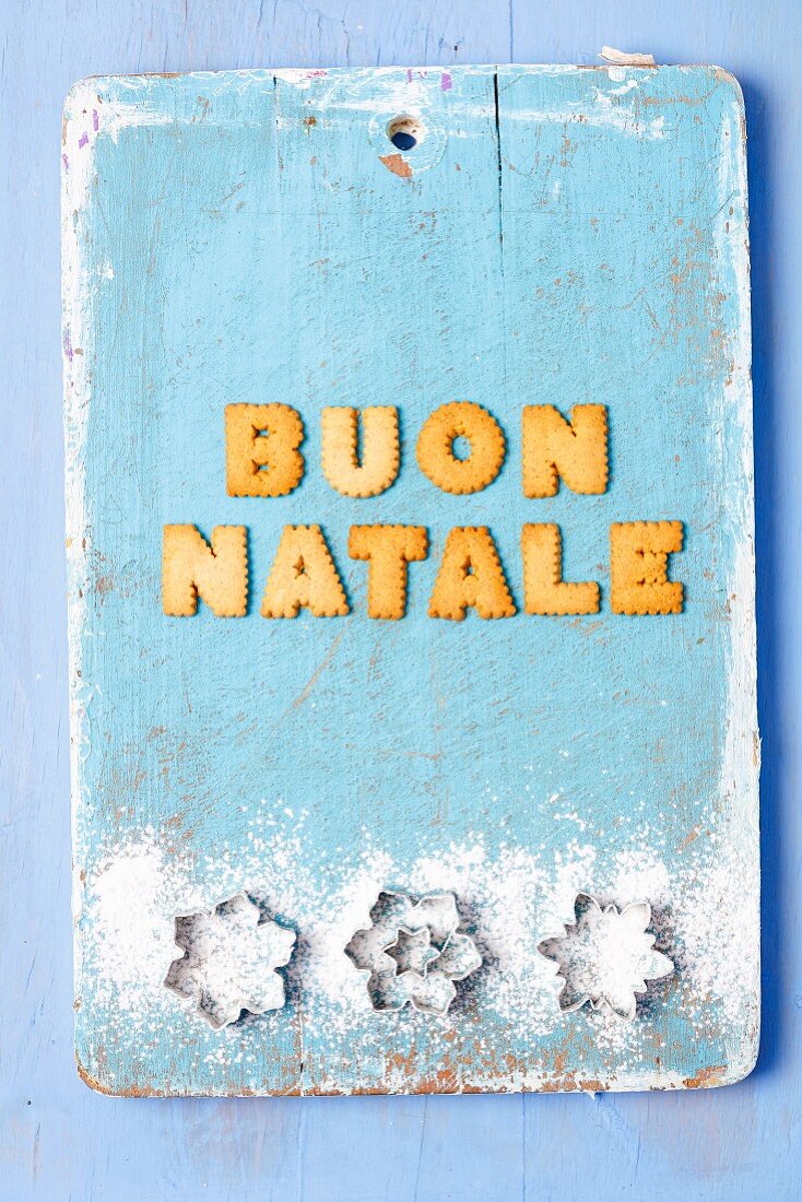 Christmas greetings written with biscuits in Italian and cutters