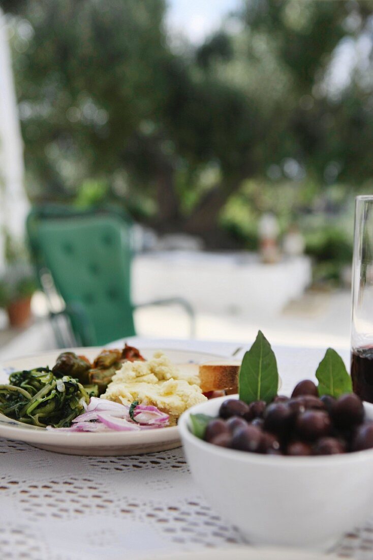 Dishes of antipasti and olives on table