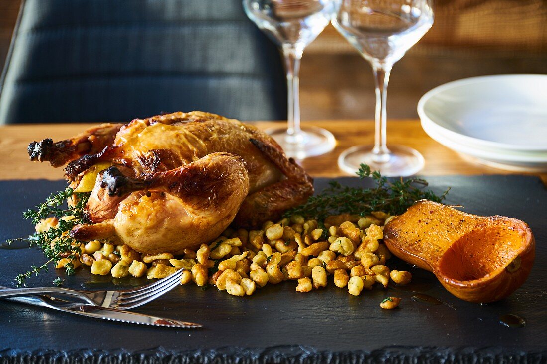 Roast chicken with pancake batter stuffing and half a roasted butternut squash