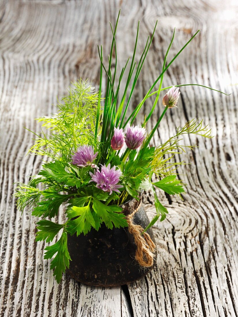 A bouquet of herbs in a dark vase
