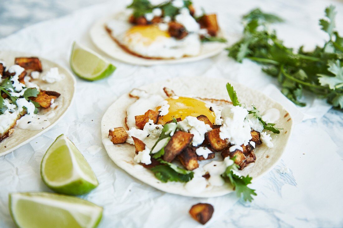 Tacos with sweet potatoes, fried egg, cheese and coriander