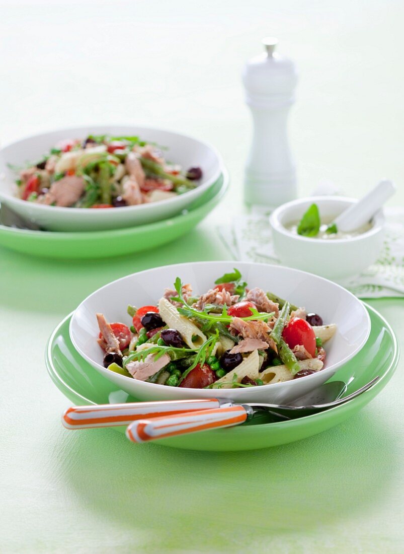 Pasta salad with pesto dressing, tuna fish, cherry tomatoes and olives