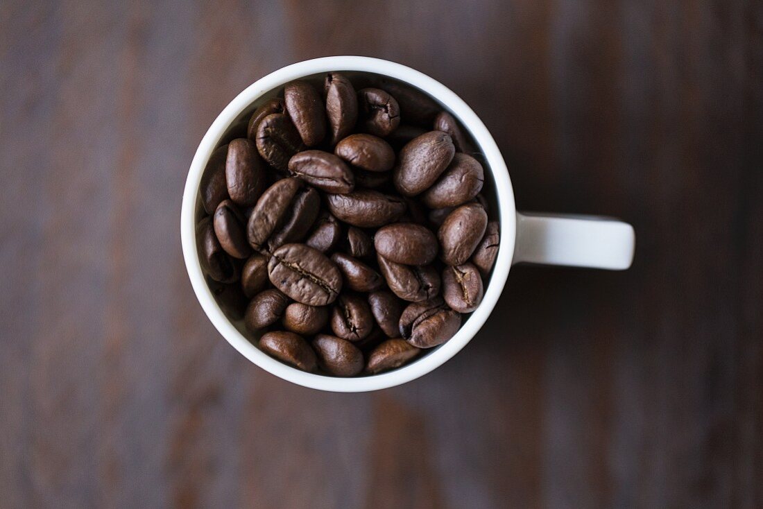 Kaffeebohnen in Espressotasse (Aufsicht)
