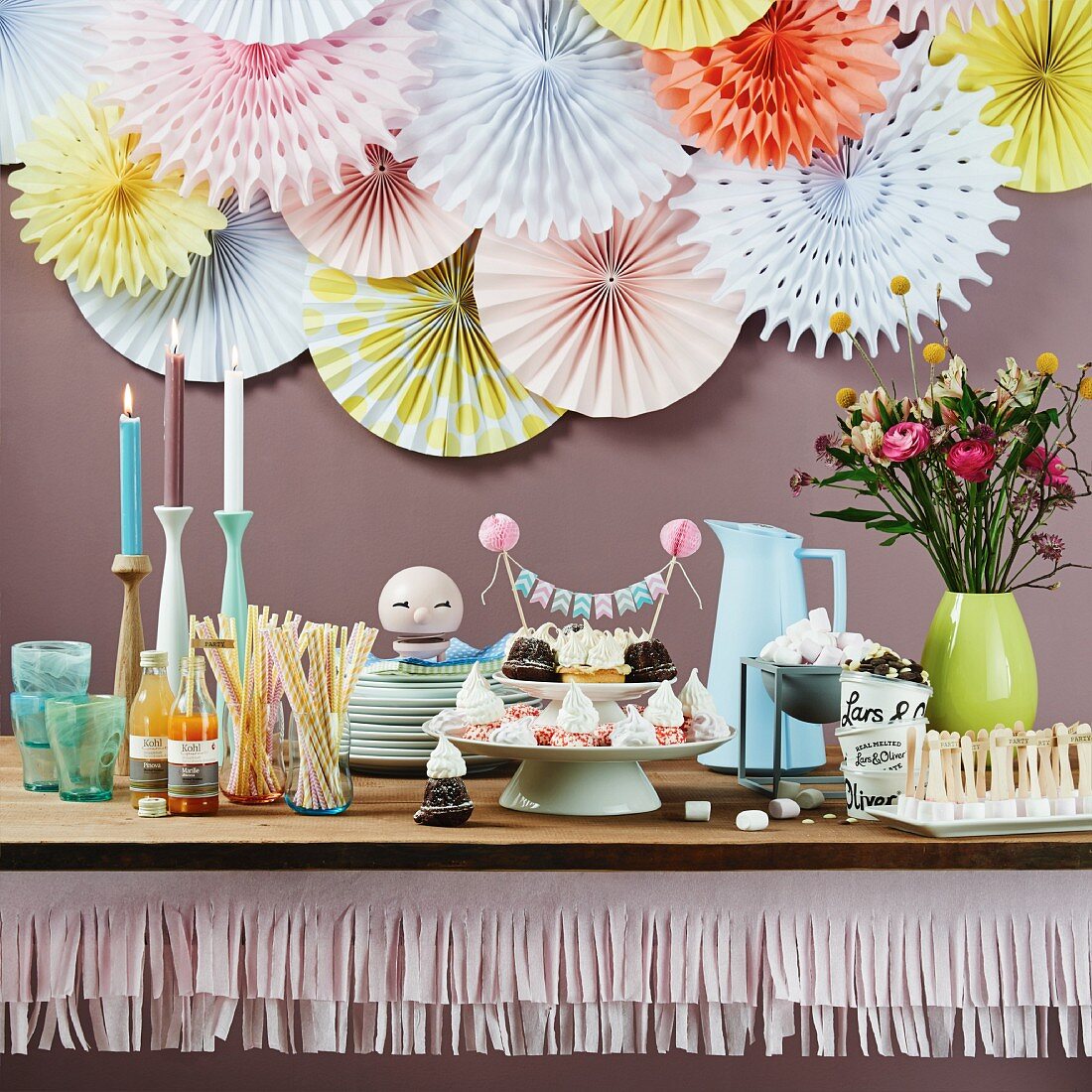 Party buffet table decorated with paper garlands and rosettes