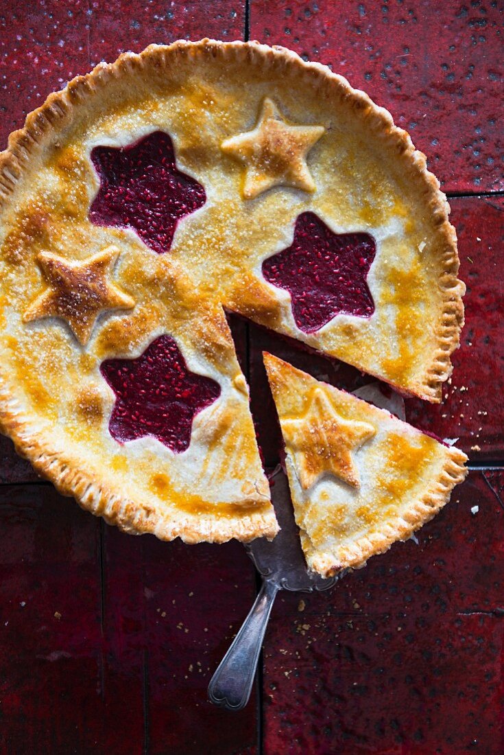 Raspberry pie with pastry stars, sliced