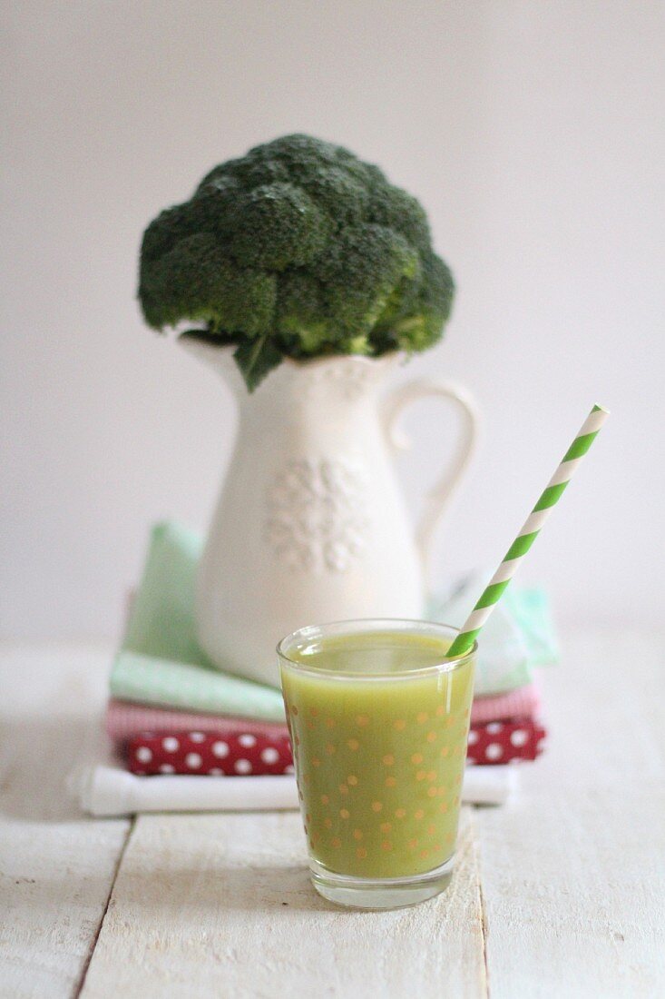 A green smoothie and broccoli in a porcelain vase